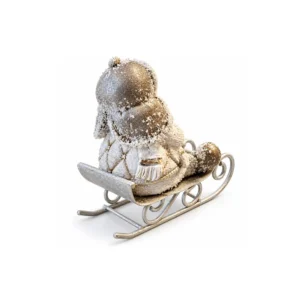 Vinterfigur sett bakfra med lue med øreklaffer, mønstrede vinterklær og snøeffekt på en slede med buede meier.